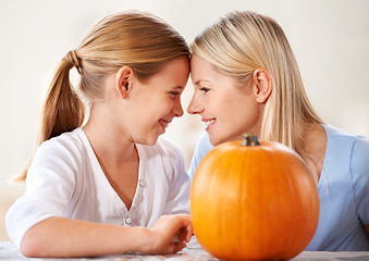 Image showing Mother, daughter or happy and pumpkin for halloween, celebration or decoration in kitchen of apartment or home. Family, face or smile and vegetable for preparation, holiday or creative event in house