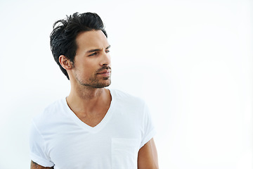 Image showing Face, space and thinking with a casual man in studio isolated on a white background for contemplation. Idea, vision and future with a confident or thoughtful young person looking away in a tshirt