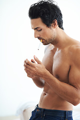 Image showing Handsome man, cigarette and smoking for addiction, drag or tobacco against a white studio background. Face of young and attractive male person, model or smoker addict relax shirtless in stress relief