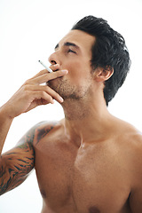 Image showing Man, cigarette and smoking for addiction or drag of tobacco against a white studio background. Face of handsome or attractive male person, model or smoker addict in relax and enjoying stress relief