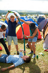 Image showing Man, friends and beer pipe at outdoor festival, camp or party together with alcohol on green grass or field. Group of people pouring drink down tube in nature by tents at event or carnival outside