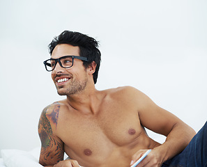 Image showing Relax, smile and a shirtless man reading a book in the bedroom of his apartment for hobby or leisure. Thinking, storytelling and the body of a happy young person lying on the bed of his home