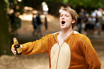 Image showing Animal, costume and man with beer at festival in field with crazy, energy and drunk in summer or holiday. Person, drink and celebrate on vacation at concert or carnival with happiness and freedom