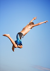 Image showing Jumping, blue sky and man with energy, outdoor and excited with nature, environment and water. Person, outside and guy with vacation, mockup space and lake with summer, weekend break and excitement