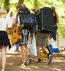 Image showing Outdoor, concert and people with backpack, walking and friends with freedom, party and festival. Men, women and group with social event, celebration and guitar with reunion, bonding together and joy