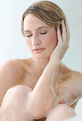 Image showing Beauty, skincare or hygiene and a woman in the bath to relax while cleaning or washing her body with soap. Water, luxury and satisfaction with a person in the bathroom of her home for wellness