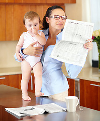 Image showing Woman, newspaper and baby while reading in kitchen with headline or article. Single mother, glasses and little girl while multitasking or juggling work from home, productivity and job with childcare