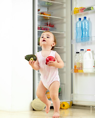 Image showing Toddler, little girl and food from fridge in kitchen for running with fresh, fruit and vegetable in hand. Youth, child and curious for organic, natural and nutrition for development of motor skill