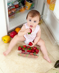 Image showing Toddler, little girl and strawberry for eating in kitchen with open, fridge and door with above view. Youth, kid and hunger for fresh, organic and fruit for healthy, balanced or snack for development