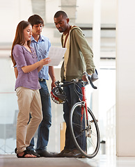 Image showing People, talking and document in office with bicycle for travel or morning commute to workplace. Bike messenger, paper and discussion of business, logistics or checklist with employees or clients