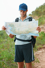 Image showing Man, hiking and map for direction, nature and guide on trail, fitness and exercise on holiday. Male person, lost and documents for information, travel and journey or adventure to forest for cardio