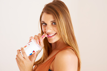 Image showing A young woman drinking a soda for happiness, studio and relax wellness on vacation. Model, smile and face with sip straw for fizzy pop, thirsty and sweet seltzer with teenager by white background