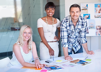 Image showing Portrait, group and happy business people at table in meeting together, cooperation or collaboration in startup. Face, creative team and designers smile at desk, diversity or brainstorming photograph