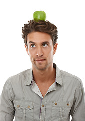 Image showing Balance, man and apple on head, thinking of food and healthy diet isolated on a white background in studio. Idea, person or green fruit for nutrition, vegan or wellness benefits, vitamin c or organic