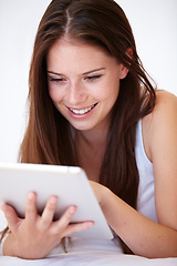 Image showing Woman, scroll on tablet and bedroom for online search, social media and sign up to streaming service for film or movies. Happy young person typing on digital technology and relax at home on her bed