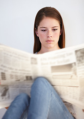 Image showing Relax, living room and a woman reading the newspaper in her home on a weekend for the daily article. Wellness, press or media with a young person in her apartment to research current world events