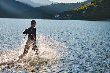 Image showing Triathlon athlete starting swimming training on lake