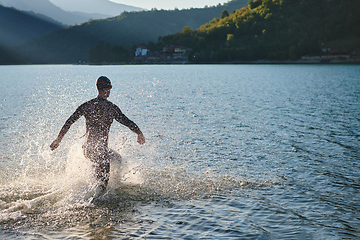 Image showing Triathlon athlete starting swimming training on lake