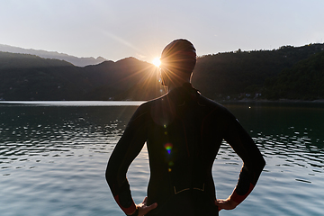 Image showing Authentic triathlon athlete getting ready for swimming training on lake