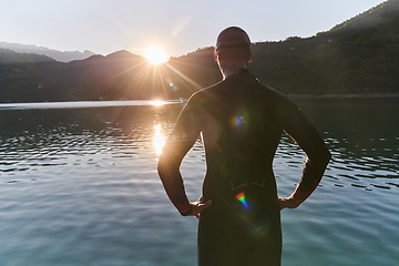 Image showing Authentic triathlon athlete getting ready for swimming training on lake