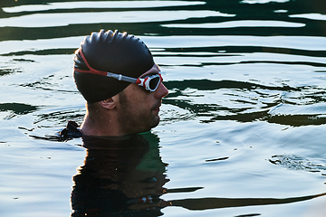 Image showing A triathlete finds serene rejuvenation in a lake, basking in the tranquility of the water after an intense training session