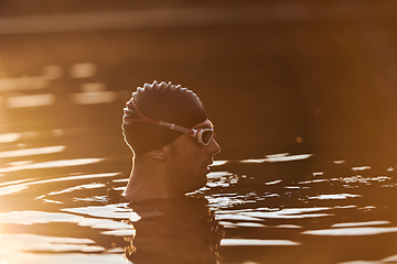 Image showing A triathlete finds serene rejuvenation in a lake, basking in the tranquility of the water after an intense training session