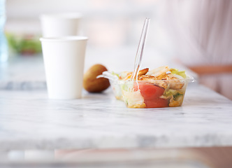 Image showing Lunch, salad and healthy food on table in office with fruit and drink for energy, nutrition or diet. Paper cup, apple and plastic container in cafeteria, buffet with fork for meal with vegetables