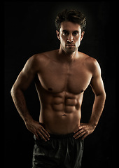 Image showing Confident, black background or portrait of man with six pack, strong abs or stomach in studio for fitness. Cool, model or ripped person with healthy body, dark shadow or abdomen muscle for wellness