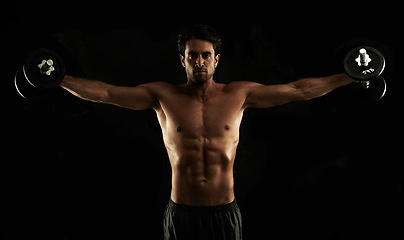 Image showing Lateral raises, dumbbells or man on black background in workout, training or exercise in studio for fitness. Portrait, sports or strong athlete with healthy body, dark shadow or six pack for lifting