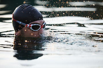 Image showing A triathlete finds serene rejuvenation in a lake, basking in the tranquility of the water after an intense training session