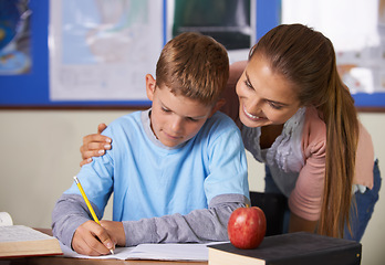 Image showing Happy teacher, support and helping student in education, learning or classroom tutor at school. Woman, mentor or teaching boy in writing, literature or test for book exam, assistance or help in class