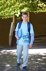 Image showing Portrait, boy and book with backpack, outdoor and smile with knowledge, education and happy. Person, outside and student with childhood development, bag and kid with joy, cheerful and learning