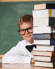 Image showing Boy kid, happy and portrait with books, classroom and learning for exam, assessment and studying for knowledge. Student child, notebook and smile for education, development and glasses by chalkboard