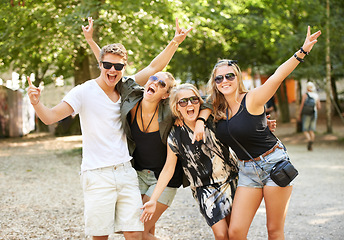 Image showing Celebration, hug and friends at a park for festival, concert or happy social gathering. Face, fun and people in a forest with freedom, energy and excited for event, reunion or party with rocker hands