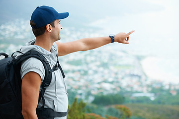 Image showing Outdoor, hiking and man with nature, pointing and adventure with direction, journey and fitness. Person, hiker and guy with wellness, travel or location with fresh air, forest or landscape with view