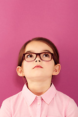 Image showing Glasses, child and looking up with thinking geek and modern fashion in a studio with serious face. Kid, eyewear and sight with outfit and nerd with accessory and pink background with confidence