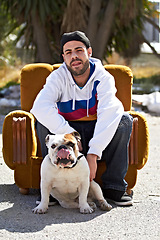 Image showing Couch, city and portrait of man with dog in street for urban fashion, casual style and trendy outfit. Hip hop, pets and person on sofa in road with canine, bulldog and best friend for relaxing