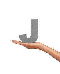 Image showing Hand of woman, font letter J and presentation of consonant isolated on white background. Character, uppercase and palm with English alphabet typeface for communication, reading and writing in studio.