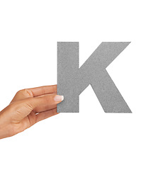 Image showing Hand of woman, font letter K and presentation of consonant isolated on white background. Character, uppercase and person with English alphabet typeface in communication, reading and writing in studio