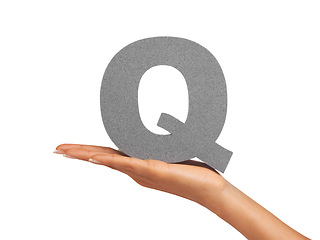 Image showing Woman, hand and letter Q or font in studio for advertising, learning or teaching presentation. Sign, alphabet or character for marketing, text or communication and grammar symbol on white background