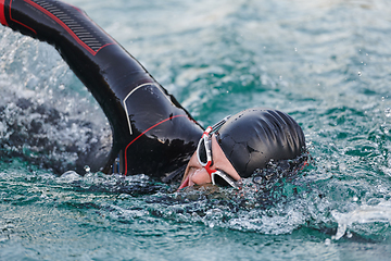 Image showing A professional triathlete trains with unwavering dedication for an upcoming competition at a lake, emanating a sense of athleticism and profound commitment to excellence.