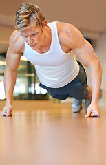 Image showing Man, gym and pushup on floor, fitness and workout for muscle development, growth and results for health. Person, exercise and bodybuilder with training process, strong arms and progress for wellness