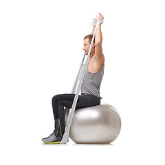 Image showing Yoga ball, resistance band and man doing exercise in studio for health, wellness and bodycare. Sport, fitness and young male person from Australia with arms workout or training by white background.