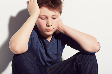 Image showing Sad, teenager and boy thinking in studio or sitting in white background with anxiety from fail in school. Mental health, stress and kid worry with depressed emotions, ideas and pressure from mistake