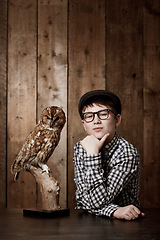 Image showing Young child, portrait and confident with thinking by owl, pride and vintage fashion with glasses in mockup. Boy, face and nerd with wise bird in retro clothes with eyewear, contemplation and smart