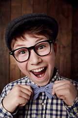 Image showing Portrait, glasses and excited kid with bow tie for fashion, retro or vintage. Happy face, nerd and smile of young boy child in hat, geek in stylish or trendy eyewear and funny laugh in New Zealand