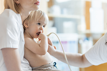 Image showing Small child being checked for heart murmur by heart ultrasound exam by cardiologist as part of regular medical checkout at pediatrician.