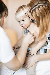 Image showing Doctor holding stethoscope and listening to child's heartbeat. Regular checkout at pediatrician at clinic or hospital. Healthcare and medical concept.