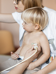 Image showing Small child being checked for heart murmur by heart ultrasound exam by cardiologist as part of regular medical checkout at pediatrician.