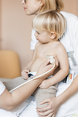 Image showing Small child being checked for heart murmur by heart ultrasound exam by cardiologist as part of regular medical checkout at pediatrician.